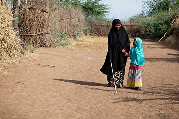 A blind woman walking with a child, Kakuma Camp, Kenya