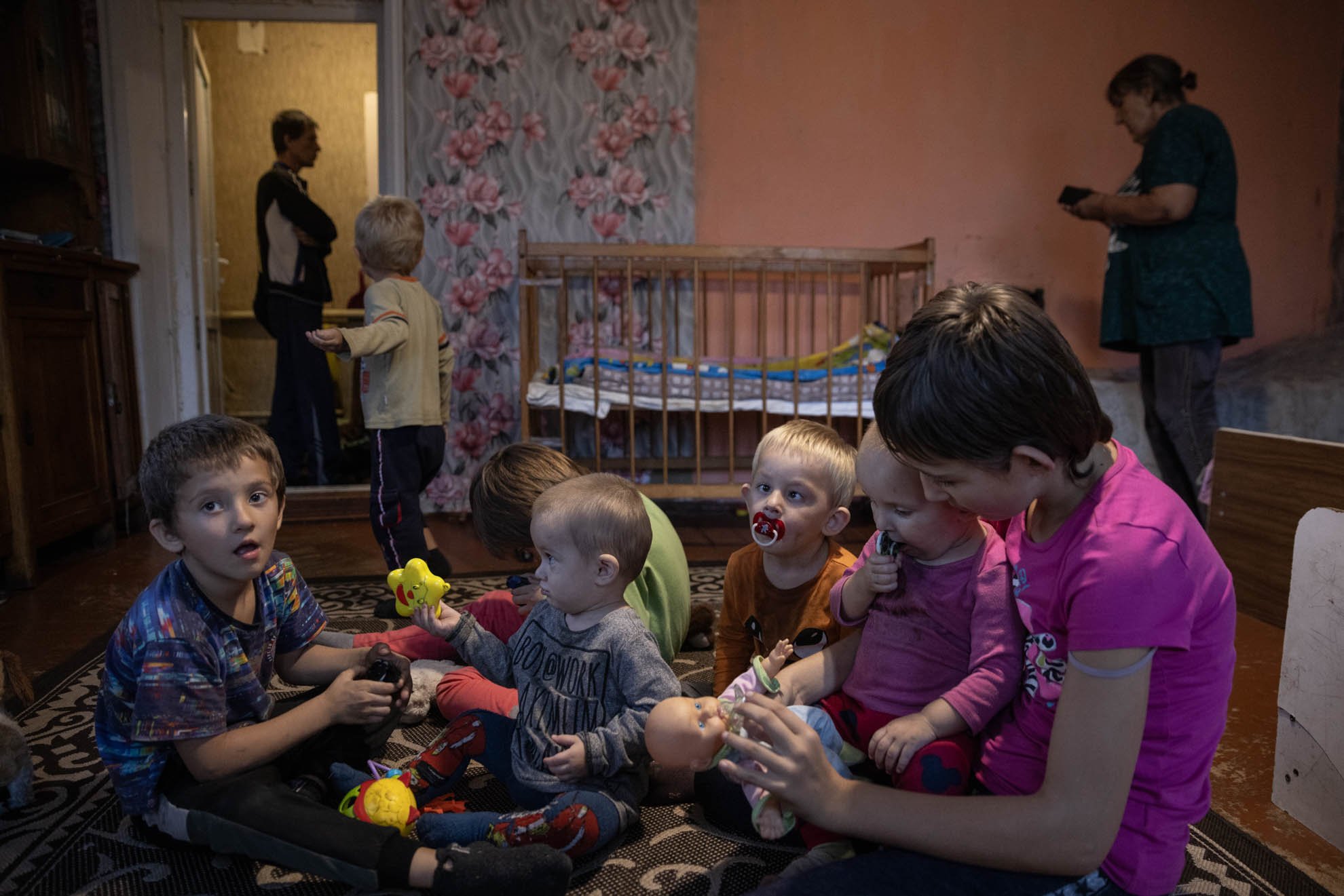 Olha and Volodymyr's children are sitting on the floor in their bedroom, playing. 
