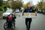 Vadim Loktionov, HI’s Basic Needs project manager, helps Pavlo, 39, who has cerebral palsy, to carry his « special needs kit » 